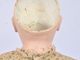 a small doll with a flowered dress on it ' s head