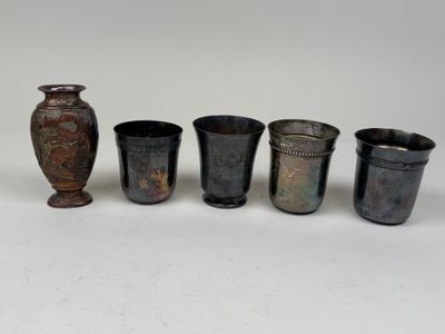 Plusieurs vases sont alignés les uns à côté des autres sur une surface blanche