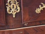 a wooden chest of drawers with a marble top
