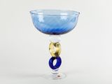 a blue glass with a gold decoration on it