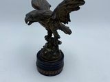 une image représentant une statue en bronze d'un aigle sur un socle