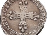 a silver coin with a cross and a crown on it
