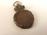 an antique pocket watch with a chain on a white surface