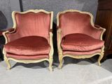 une paire de fauteuils en velours rouge avec des finitions dorées et des pieds en bois