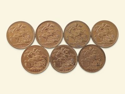 Six pièces de monnaie britanniques sont disposées en ligne sur une surface blanche