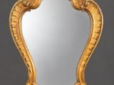 an ornately carved mirror is shown against a gray background