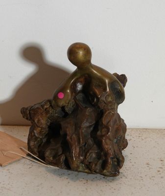 une statue représentant un homme assis sur une souche d'arbre