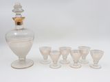 six verres et une carafe posés les uns à côté des autres