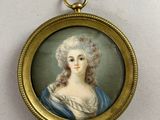 an antique miniature portrait of a woman in a blue dress