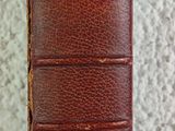 an old book sitting on top of a white cloth covered table