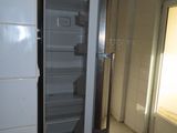 a refrigerator that is open in a room with tile flooring