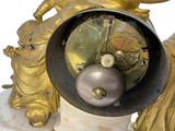 a gold clock sitting on top of a marble base