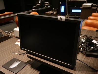 un écran d'ordinateur posé sur un bureau dans une pièce