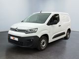 une camionnette blanche garée dans une pièce au sol noir