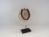 a close up of a necklace on a stand with a mirror