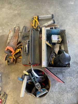 de nombreux outils qui traînent dans une boîte posée par terre