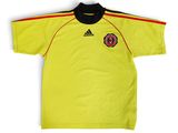 un t-shirt jaune avec un col noir et une bande rouge sur la poitrine