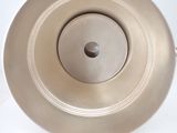 a metal bowl with a metal lid on a white table