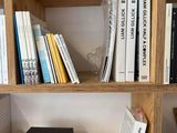 a bookshelf with several books and a speaker on it