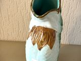 un vase en céramique orné d'un visage marron et blanc