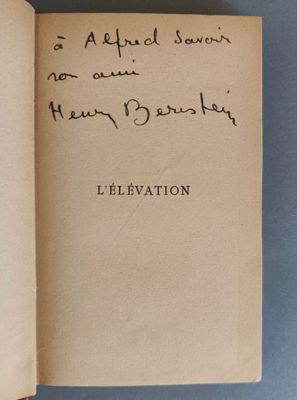 un livre ouvert, sur lequel on peut lire des notes manuscrites, posé sur une table