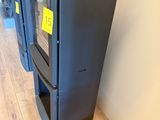 a black stove sitting on the floor next to a wall