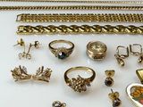a lot of gold jewelry on a white table