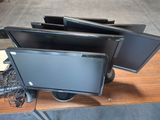 three monitors sitting on top of a desk with a keyboard and mouse