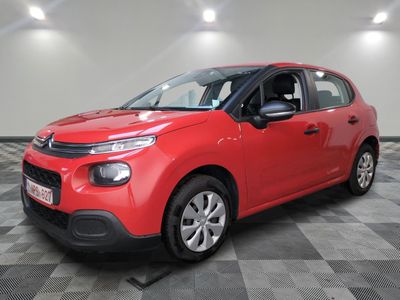 a red citrole is parked in a room with a checkered floor