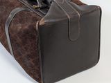 a brown piece of luggage sitting on a white surface