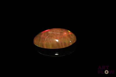 une image représentant un objet noir sur lequel brille une lumière rouge
