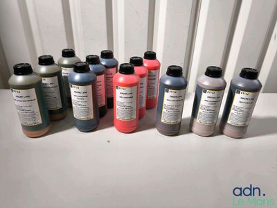 de nombreuses cartouches d'encre de différentes couleurs alignées sur une table