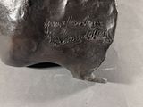 a bronze sculpture of a hand with writing on it