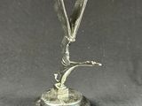 statue of a bird on a pedestal with a black background