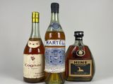 three bottles of liquor are lined up on a white surface