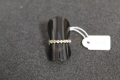 une photo montrant une bague et une étiquette posées sur une table
