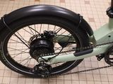 a green bicycle with a chain attached to the front wheel