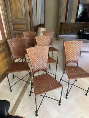 six chairs in a room with wood paneled walls and a black chair