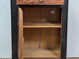 a small cabinet with a door open on a tile floor