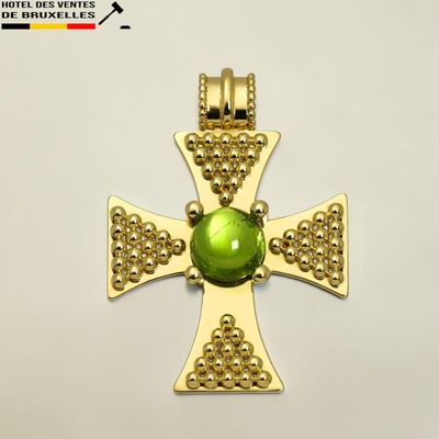 une image représentant une croix en or ornée d'une perle de verre verte