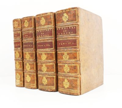 three books are stacked on top of each other on a white surface