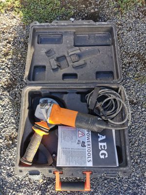 a tool in a case on the ground next to the grass