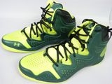 des chaussures de basket vertes et jaunes avec des lacets noirs sur une base blanche