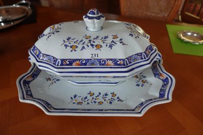 une assiette bleue et blanche avec un couvercle, posée sur une table en bois