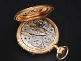 pocket watch on a black surface with a black background
