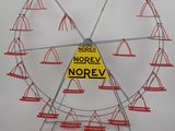 une grande roue ornée de cônes et d'un panneau sur lequel on peut lire « norev norev »