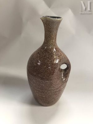 a brown vase that is sitting on a white surface
