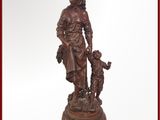 statue d'une femme avec un enfant et un chien, posée sur un socle