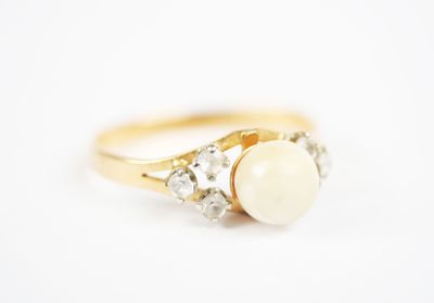 a close up of a gold ring with a pearl and diamonds