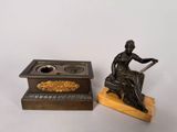a statue of a woman sitting on a chair next to a candle holder